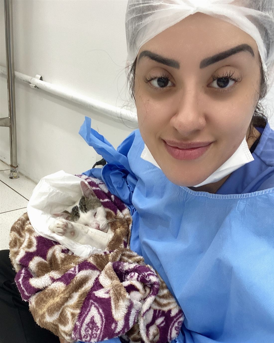 Dra. Kah com um gatinho enrolado em uma manta no colo